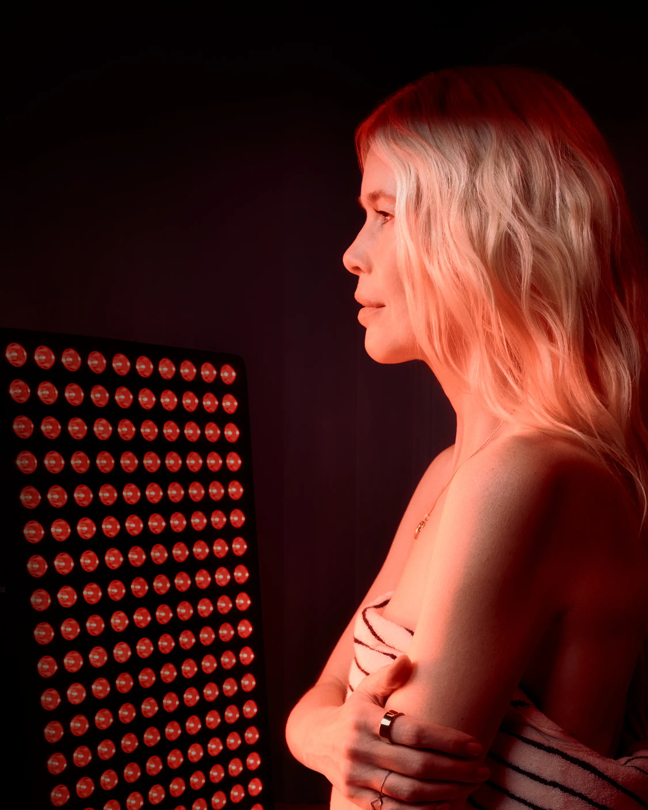 Woman using a full-body red light panel